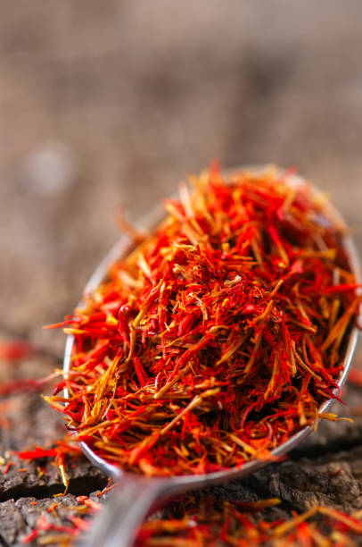 istock Dried saffron spice in a spoon on a wooden background. 959547598