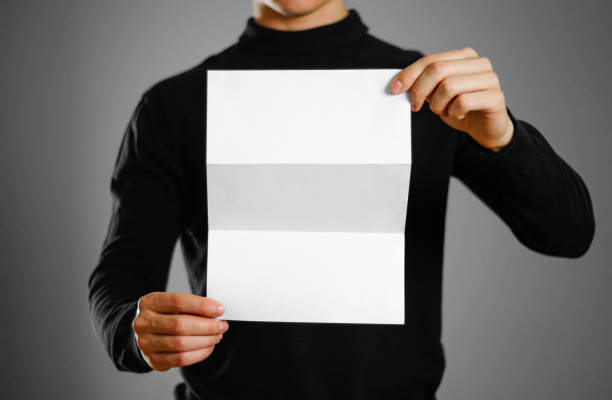 istock Man showing blank white flyer brochure booklet. Leaflet presentation. Pamphlet hold hands. Man show clear offset paper 959550994