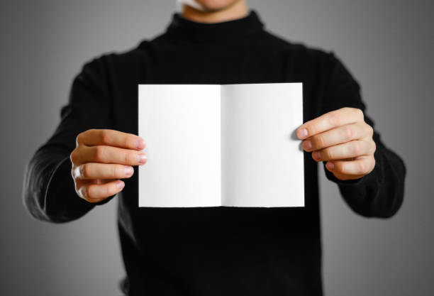 istock Man showing blank white flyer brochure booklet. Leaflet presentation. Pamphlet hold hands. Man show clear offset paper 959551008