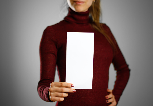 Woman showing blank white flyer paper. Leaflet presentation. Pamphlet hold hands. Girl show clear offset paper. Sheet template