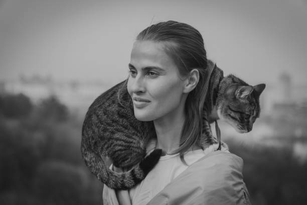 istock Cat on a leash. A girl is walking with a cat that sits on her shoulder 959555110