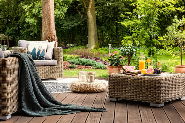 Rattan table with fruit Close-up of rattan table with fruit and juice on it standing on a wooden patio in a spa facility garden garden lights candle stock pictures, royalty-free photos & images