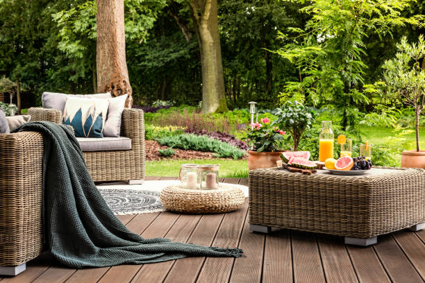 Rattan table with fruit Close-up of rattan table with fruit and juice on it standing on a wooden patio in a spa facility garden Wicker stock pictures, royalty-free photos & images