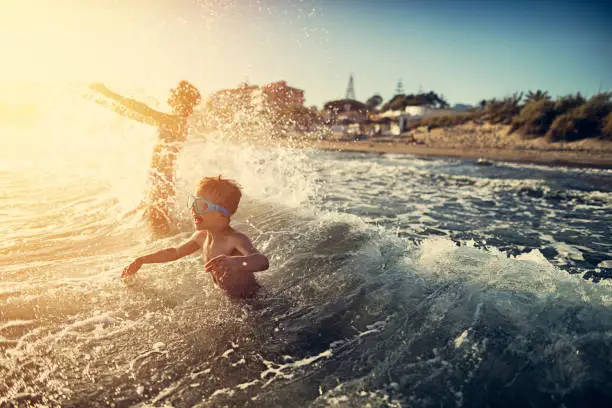 Photo of Brother and sister splashing in summer sea