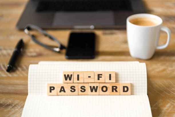 istock Closeup on notebook over wood table background, focus on wooden blocks with letters making WI-FI PASSWORD words 959562072