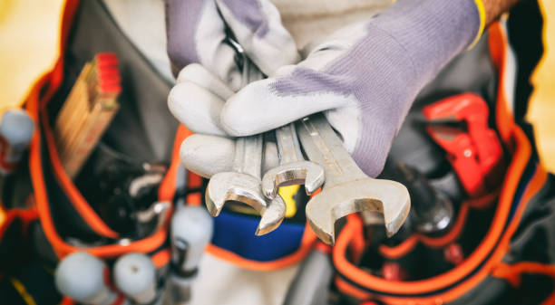 istock Worker with tool belt holding set of spanners 959566930