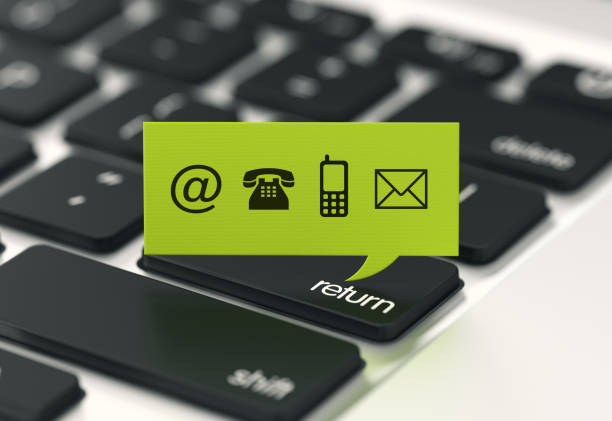 Green speech bubble with contact us symbols on a laptop keyboard background. Horizontal composition with selective focus and copy space.