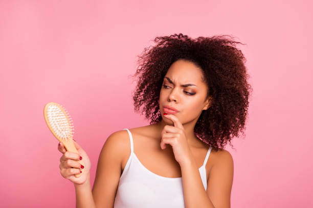 Attractive, pretty, charming, thoughtful, unhappy, sad girl looking at comb in hand touching chin with finger, having dry, oiled hair loss, she need mask, lotion, balm, isolated on pink background Attractive, pretty, charming, thoughtful, unhappy, sad girl looking at comb in hand touching chin with finger, having dry, oiled hair loss, she need mask, lotion, balm, isolated on pink background angry hairstylist stock pictures, royalty-free photos & images