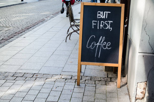 Sign outside a cafe (horizontal) Sign outside a cafe in Vilnius, capital city of Lithuania, with the words: "But fist, coffee" on it. Horizontal picture. Best Coffee stock pictures, royalty-free photos & images