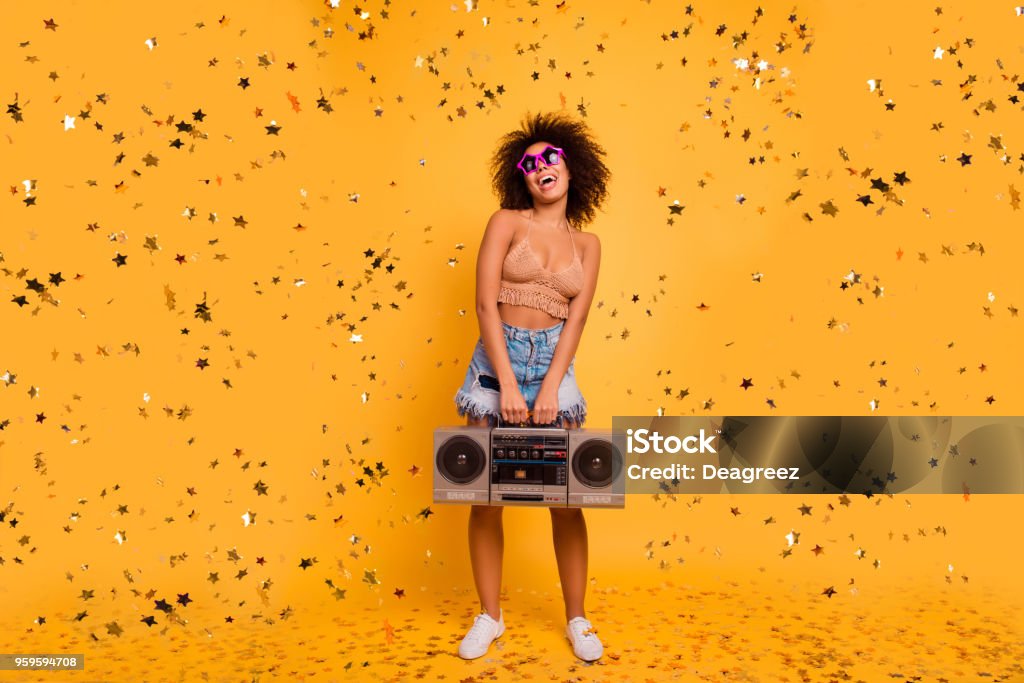 Che la festa inizi! A figura intera di giocoso pazzo divertente eccitato allegro con pelle di bronzo patrybotch tiene retrò vecchio stile boombox, organizzando una festa, isolato su sfondo giallo - Foto stock royalty-free di Musica