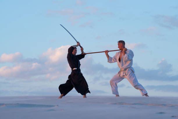 istock Resolute men practicing martial arts with a traditional Japanese weapon 959599640