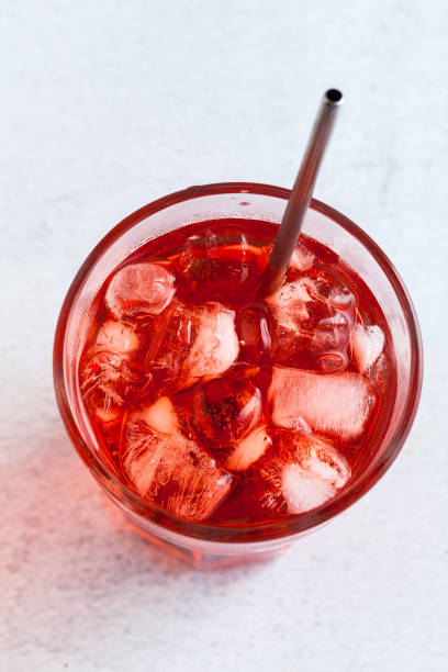 istock red drink with ice cubes in a glass with a straw. close-up shot 959605594