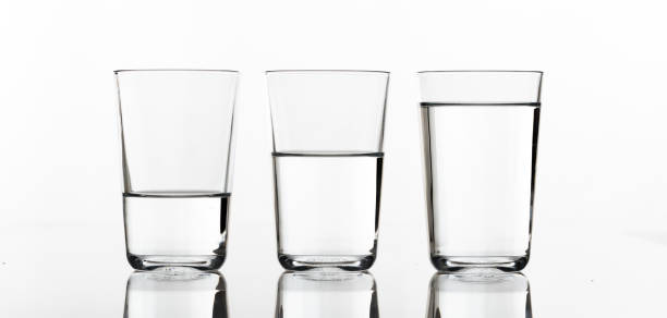 trois verres d’eau sur fond blanc - glass water half full empty photos et images de collection