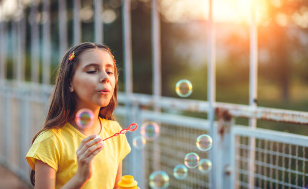 istock Cute little girl blowing soap bubbles 959612086