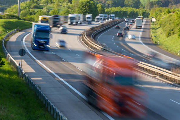traffic jam on german highway traffic jam on german highway with burred cars and trucks through green hilly landscape autobahn stock pictures, royalty-free photos & images
