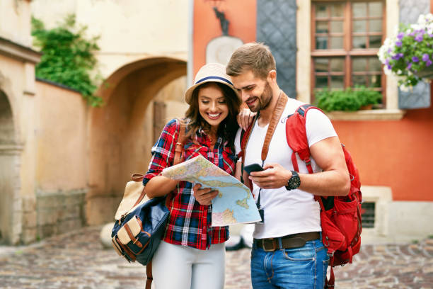 istock Beautiful Tourist Couple Traveling Using Map And Phone. 959613562