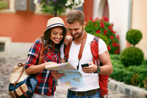 istock Young Tourist Couple Looking For Attractions On Map. 959618316