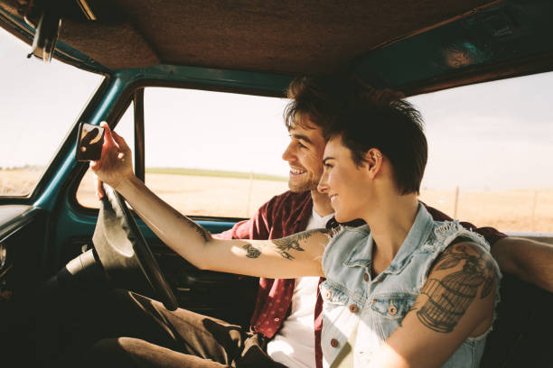 istock Young couple on a road trip driving in car 959626458