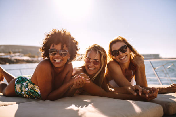 istock Cheerful women sunbathing on private yacht 959629458