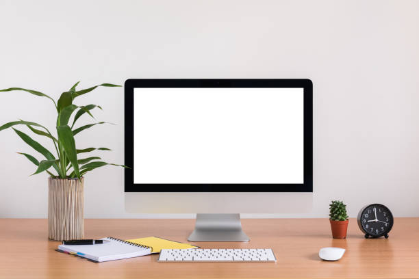 istock All in one computer, mouse, keyboard, note book, pen, cactus and tree vase  on wooden table 959630800