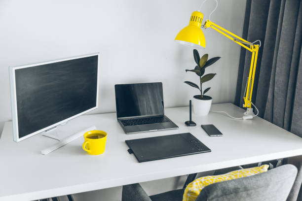 istock workplace. white desk with laptop and yellow cup. designer working place 959634452