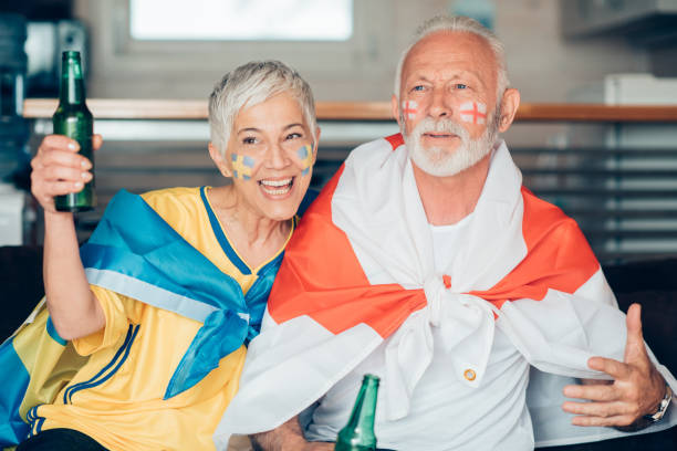 istock Senior couple drinking beer and watching soccer from home 959634650