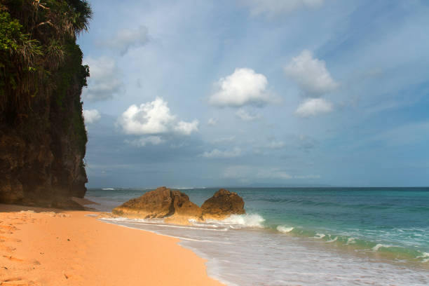 istock Tropical beach with yellow sand, azure ocean and big rock 959639022