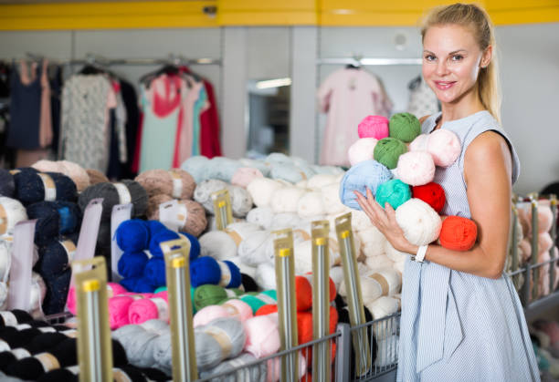 istock Young woman choosing colored thread for knitting 959642822