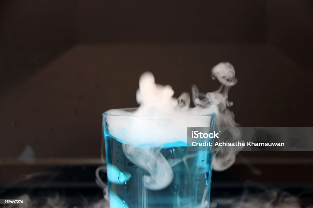 Ghiaccio Secco In Un Bicchiere Di Acqua Blu E Generare Fumo Bianco