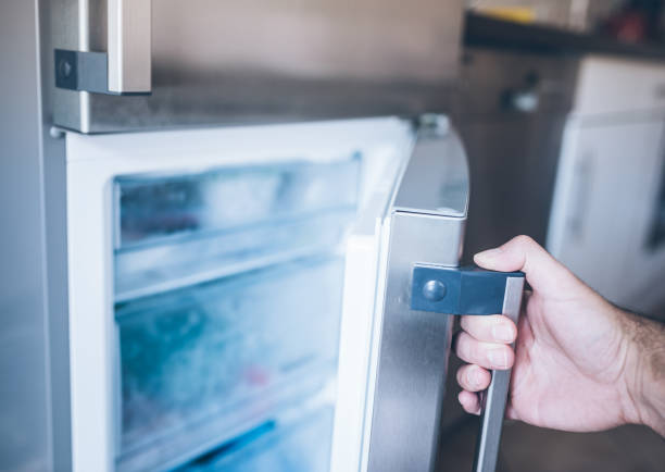 mão de um homem abrir a porta do congelador na cozinha - freezer - fotografias e filmes do acervo