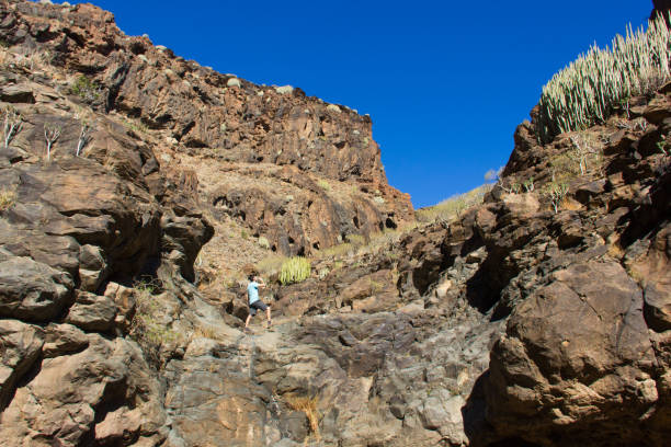 randonneurs au sommet du rocher de la falaise dans les îles canaries - thirsty desert men reaching photos et images de collection