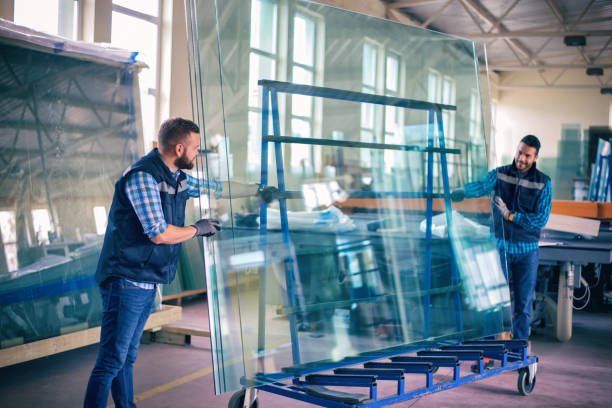 lavoratori che confezionano lastre di vetro in magazzino - glass factory foto e immagini stock