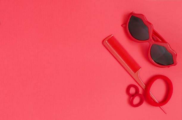 istock Red sunglasses, comb, hair elastic bands. Red background 959661314