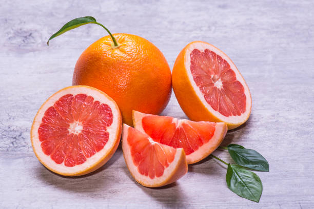 istock Grapefruit whole, half and slice, green leaf, juicy ripe isolated on a gray background 959673550