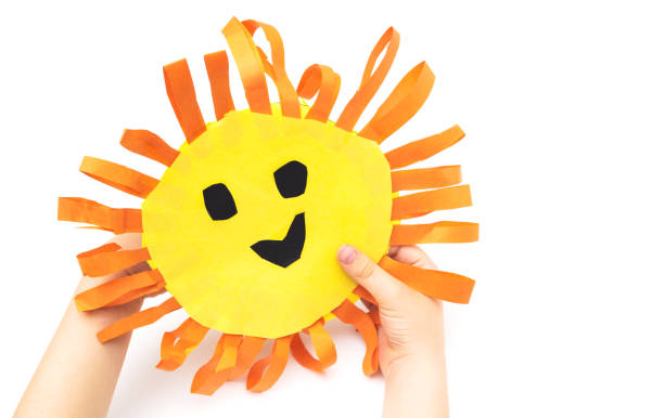 istock Children's handmade in hands from colored paper - the sun with a smile 959674742