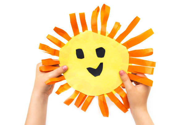 istock Children's handmade in hands from colored paper - the sun with a smile 959674790