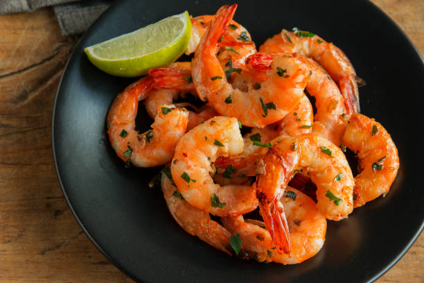 istock fried roasted shrimps in plate with lemon greens parsley garlic 959681682