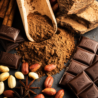 Cocoa powder, chocolate, nuts and spices on a wooden table. Food photography