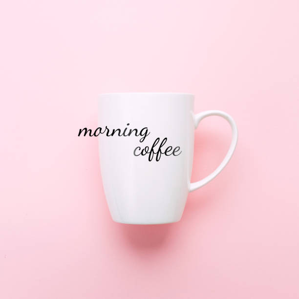 istock White cup on pink background with text Morning Coffee. 959692796