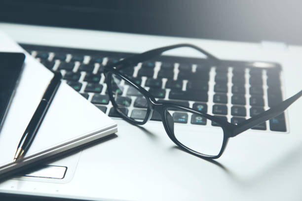 istock office desk with laptop, glasses and other items 959697584