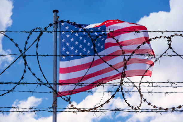 istock USA Border with American Flag and barbed Wire 959698498