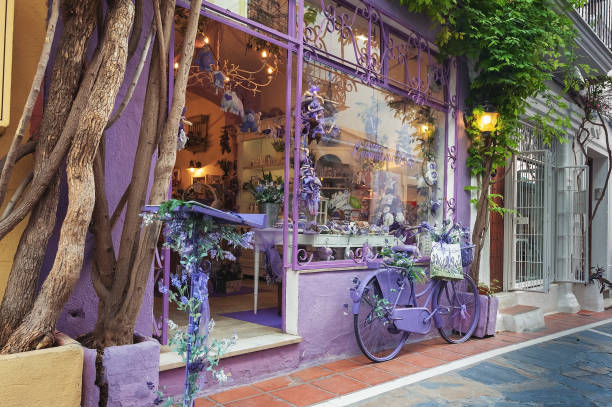 fachada de loja souvenir violeta, decorada com bicicleta violeta estacionado perto da parede - editorial concepts and ideas retail place store - fotografias e filmes do acervo