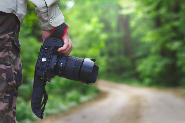 istock Photographer holding a camera outdoors 959701568