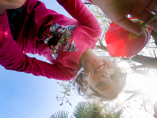 Smiling Young Girl Picking Up Poppy Flower.