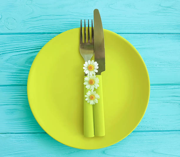 istock empty plate on a blue wooden background daisy flower fork, knife 959711572