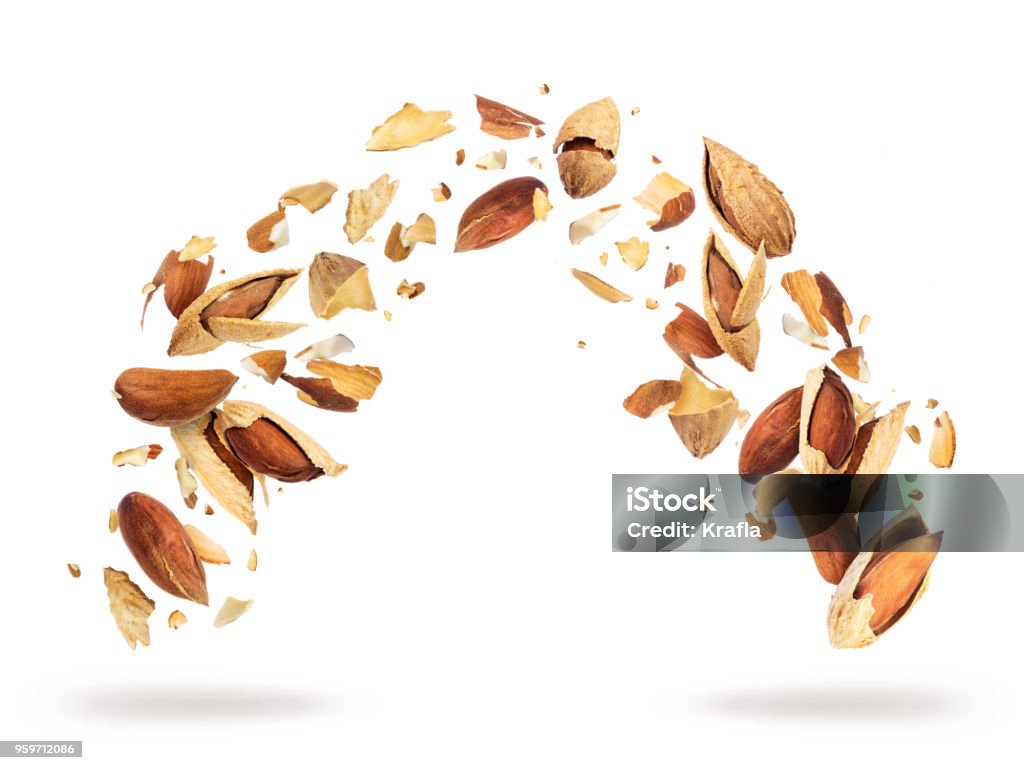 Almonds crushed into pieces, frozen in the air on a white background Almond Stock Photo