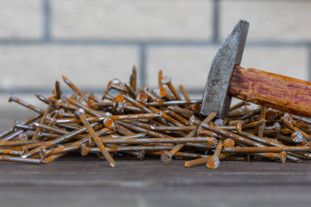 istock Rusty nails and an old hammer on the wooden background 959712534