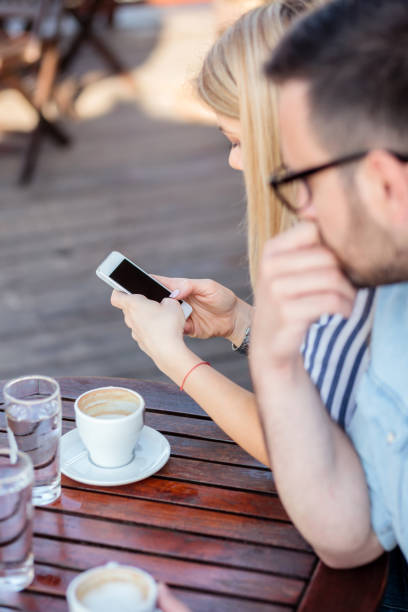 istock Jealous young man looking at girlfriend's phone while she is typing a message 959713422