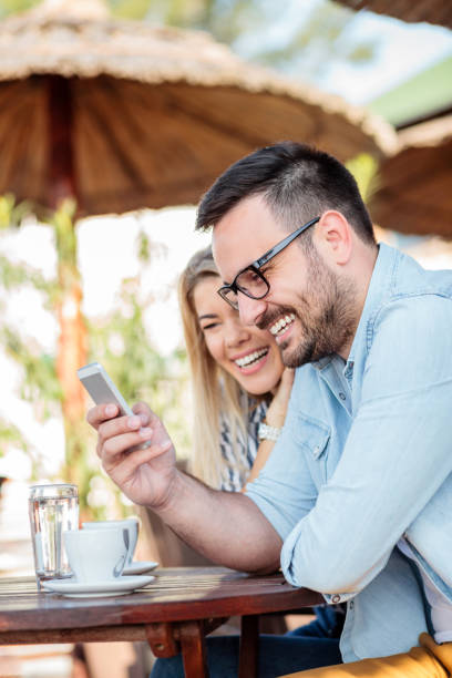 istock Happy young couple smiling and browsing internet on a smart phone 959713880