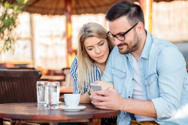 felice giovane coppia sorridente e navigare in internet su uno smartphone - 11262 foto e immagini stock